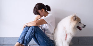 Frustrated Woman and Dog Sitting Back to Back